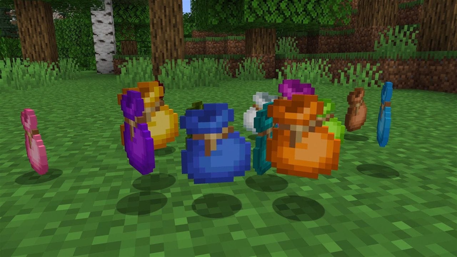 Bundles in different colors lie on the grass in a forest